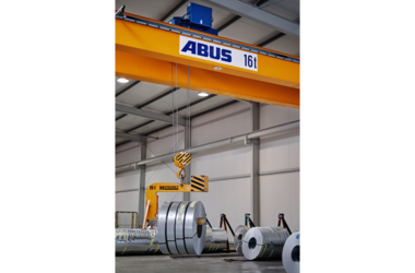 Double girder travelling crane with load capacity of 16 t lifts several steel coils
