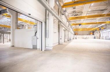 Mounted ABUS single girder travelling cranes in empty hall of Caljan company