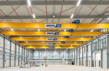 View into a large production hall with five ELK overhead travelling cranes on a common crane track.
