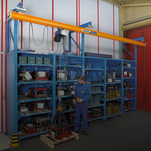 Monorail suspension system with chain hoist in front of a rack storage system