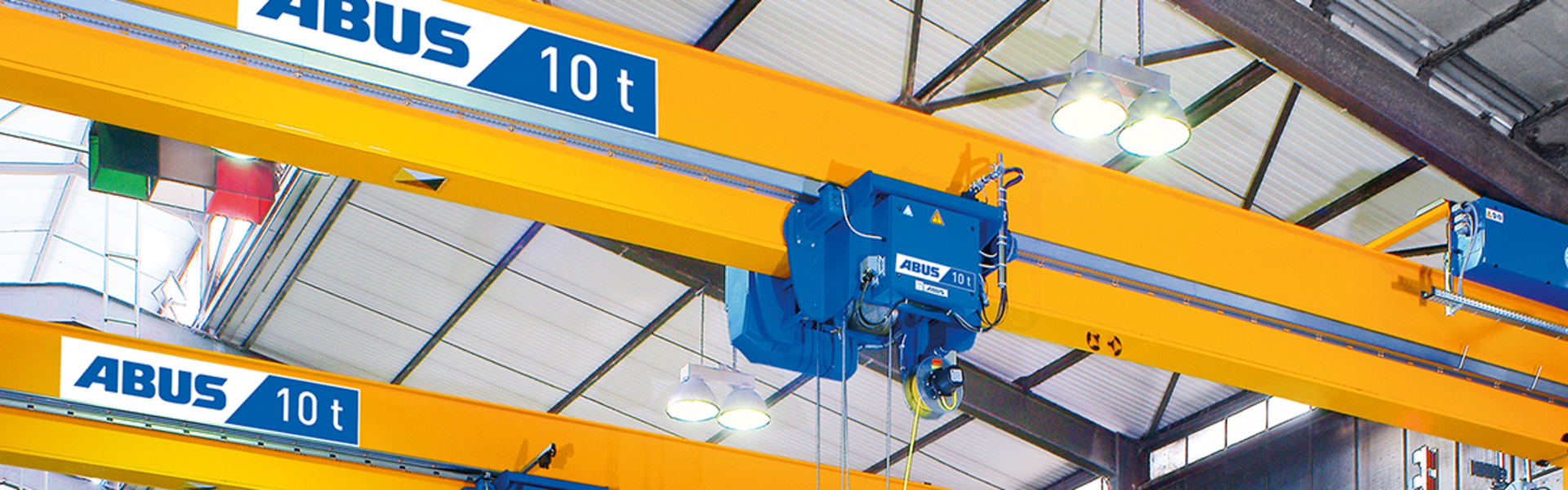 ABUS double-girder overhead crane with a wire rope hoist and a 10-tonne load capacity in an industrial hall.