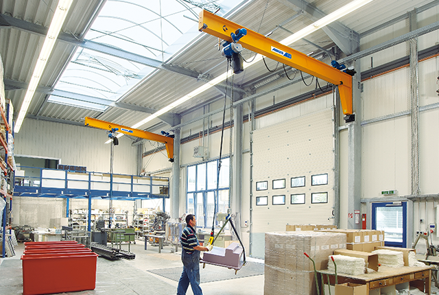 ABUS VW wall-mounted jib crane in a production hall.